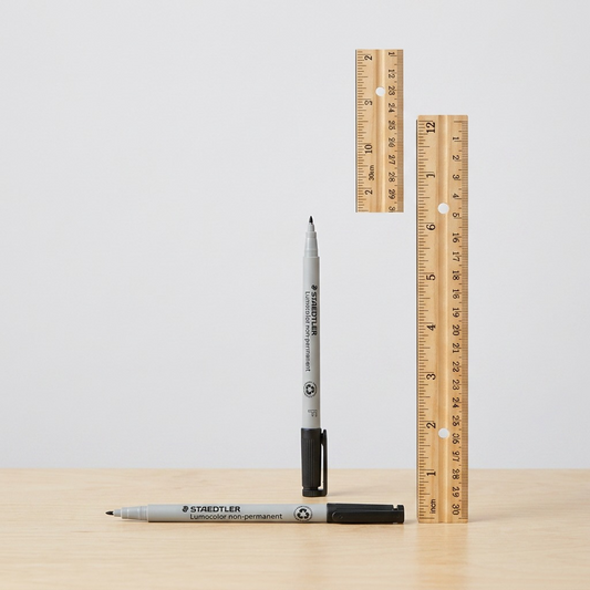 A scale reference image showing the STAEDTLER Lumocolor maker beside a standard 12-inch ruler.