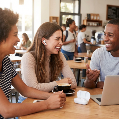 A lifestyle photo showing three friends laughing in a cafe. One woman is wearing the white Wicked Audio Driftr earbuds, and the open charging case is on the table.