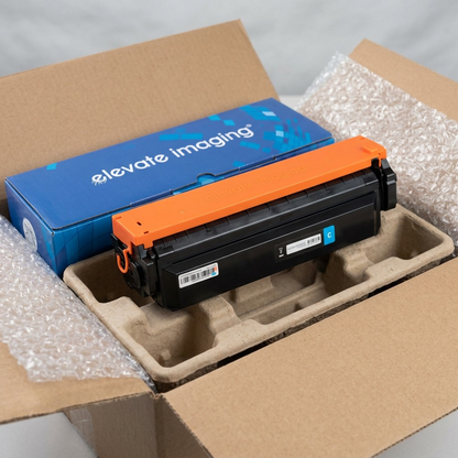 A close-up unboxing of an Elevate Imaging toner cartridge with its protective blue box, safely cradled in molded pulp packaging.