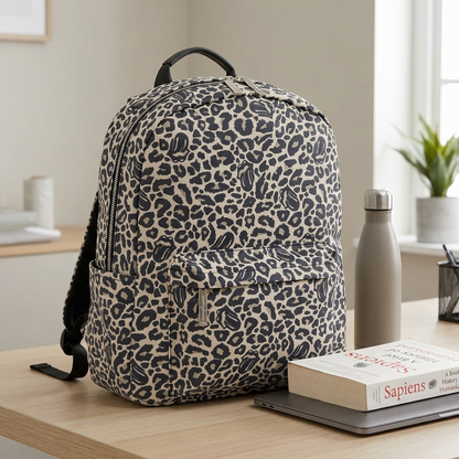 A visual comparison image shows the leopard-print backpack from image_0.png standing at full scale on a wooden desk next to a physical paperback book and a small water bottle for an accurate size reference.