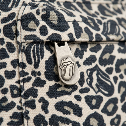 A macro photograph showing the unique tongue-logo patterned canvas and a precision branded zipper pull on the Bugatti Rolling Stones backpack.