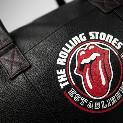 An extreme close-up of The Rolling Stones logo print and black pebbled leather texture on the dUf6082RS-VIN duffle bag.