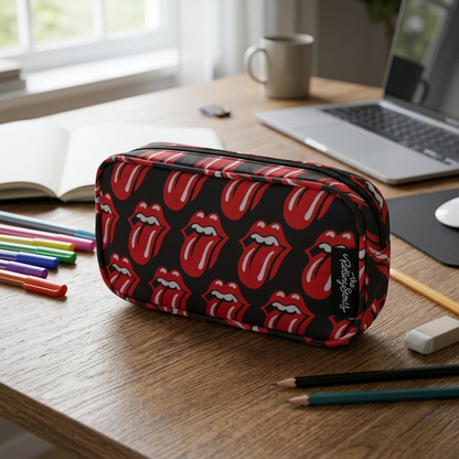 A lifestyle image featuring the black Rolling Stones pencil case, patterned with red and white tongue-and-lips logos and black side tag, placed as if in use on a wooden desk.