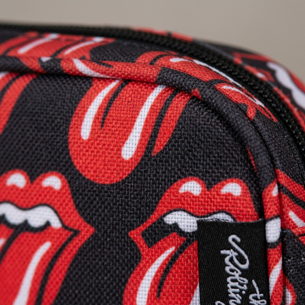 An extreme close-up of the Rolling Stones patterned fabric on the pencil case, showing polyester texture and clear stitching.