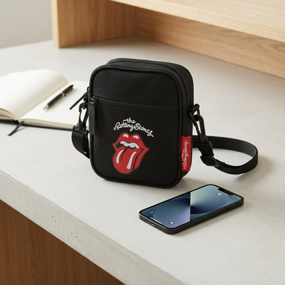 Scale image of The Rolling Stones small crossbody bag next to a standard smartphone on a desk.