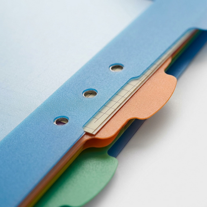 Extreme macro view showing the textured plastic tab and its connection to the main blue divider body.