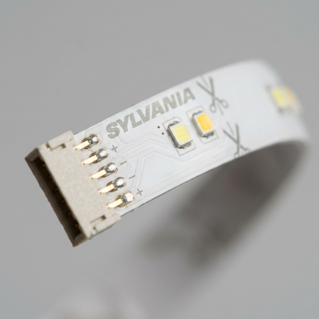 Macro close-up of a SYLVANIA smart LED light strip extension, showcasing the detailed components and connector pins.