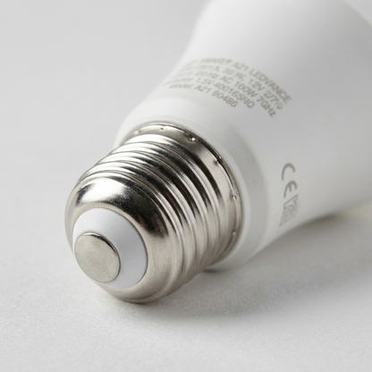 A detailed macro photograph showing the high-precision E26 screw base and ceramic finish of a smart LED bulb.