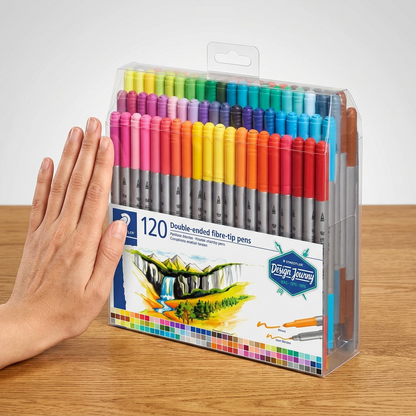 STAEDTLER 120-pen set (MPN: 3200-TB120) scale reference next to a human hand on a wooden desk.