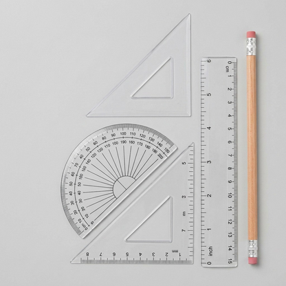 A photo of the transparent Staedtler geometry set components from the package displayed next to a standard AA battery.