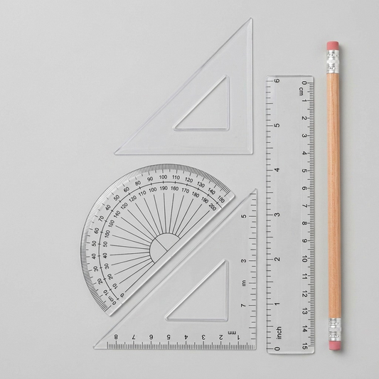 A photo of the transparent Staedtler geometry set components from the package displayed next to a standard AA battery.