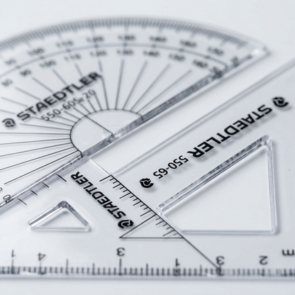 Macro photo of precision centimeter and degree scales on clear plastic with sharp black STAEDTLER markings.