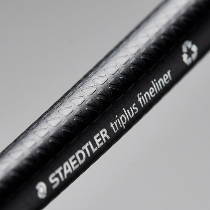 An extreme close-up photograph of the STAEDTLER triplus fineliner texture and text.
