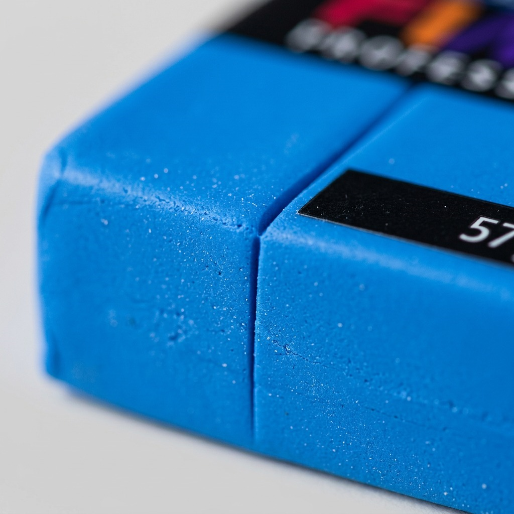 An extreme close-up detail shot of the vibrant blue STAEDTLER FIMO Professional modeling clay, showing its fine, unworked texture and matte finish.