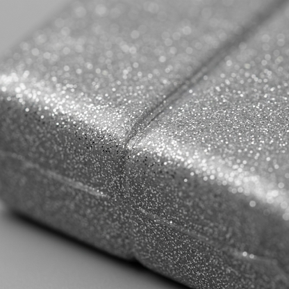 A detailed macro photograph showing the sparkling glitter surface texture of silver metallic polymer clay.