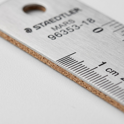 A macro shot focusing on the etched numbers, gradations, and the textured cork backing of the ruler.