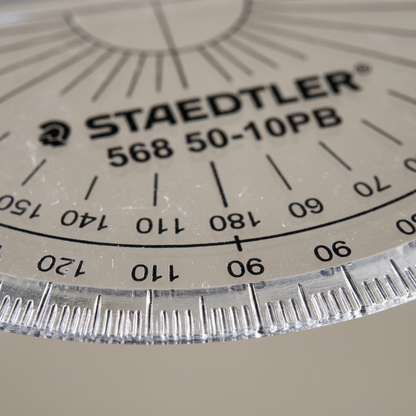 Macro close-up of precise milled clear degree markings on the STAEDTLER protractor.