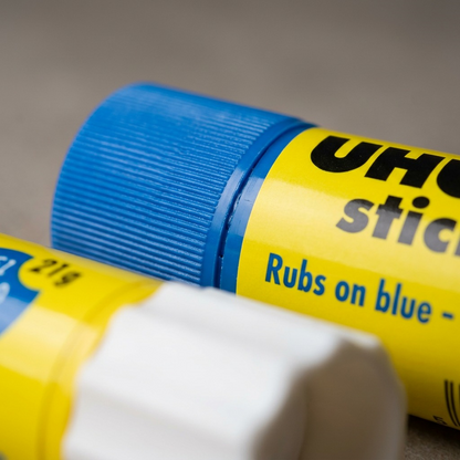 Close-up macro of UHU blue glue stick fine cap grooves and smooth label finish.