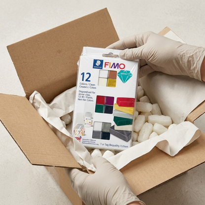 A photograph of an unboxed STAEDTLER Set Modelling Clay Fimo Effect 12 Color Pack in protective wrap.