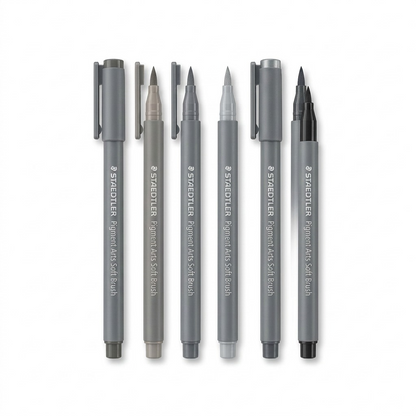 A pure high-resolution hero shot showing six grey and black STAEDTLER Pigment Arts Soft Brush markers.