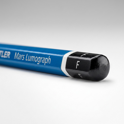 A detailed macro photograph showing the 'F' grade marking on the end of a blue and white STAEDTLER pencil.