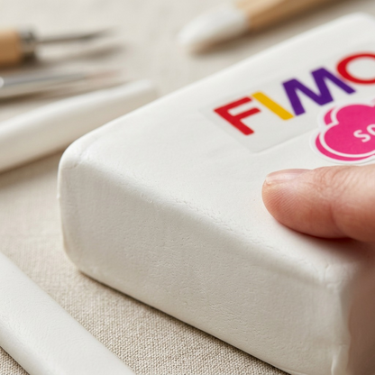 Macro photo detail of the smooth, matte surface of the white Fimo Soft clay block.