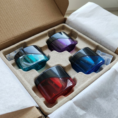 The four miniature oval pencil sharpeners are seen in protective shipping packaging and individually pristine inside a box.