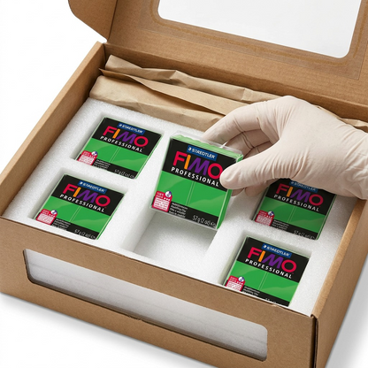 A hand carefully lifts detailed green FIMO Professional blocks from custom protective foam inserts within a cardboard box; realistic and secure unboxing.