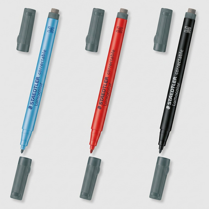 A visual comparison matrix grid for the Staedtler correctable whiteboard marker, showcasing the original blue marker, a red variant, and a black variant, each displayed with its respective cap and cap eraser in a consistent product shot format.