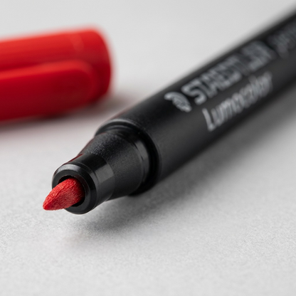 Extreme macro shot focusing on the red fine fiber tip of the STAEDTLER Lumocolor permanent special marker.