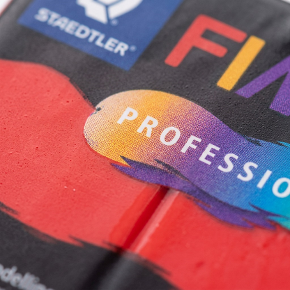 Macro detail of Fimo Professional True Red clay packaging texture.