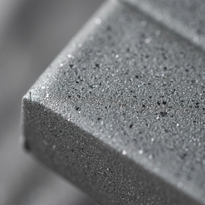 Extreme macro photo showing the fine metallic flake texture within the matte grey FIMO Effect clay and a clean label corner.