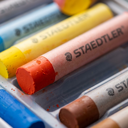 Extreme close-up macro of an opened oil pastel set, showing vibrant colors and dense finish.