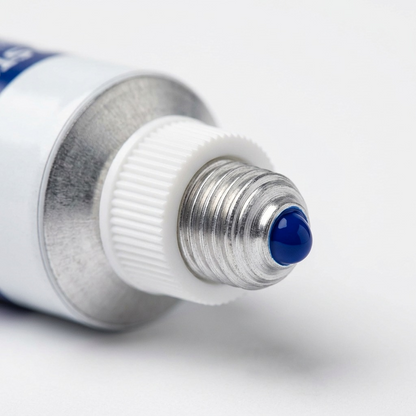 Macro inspection showing the nozzle and threaded metal neck of a blue acrylic paint tube.