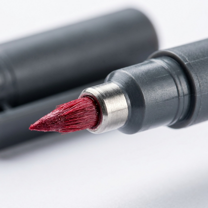 Extreme visual close-up of a Staedtler Pigment Arts brush pen tip, showing ink-saturated fibers and texture.