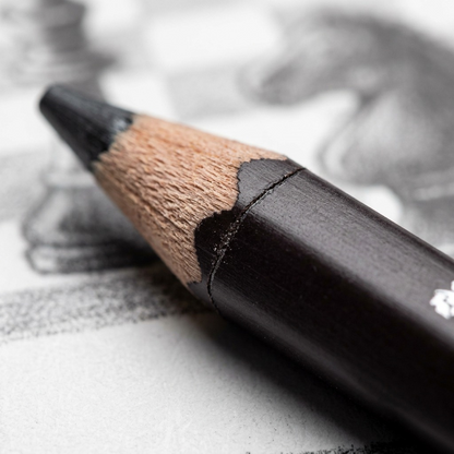 Macro detail of the wooden pencil texture, showing the seam and matte black coating up close.