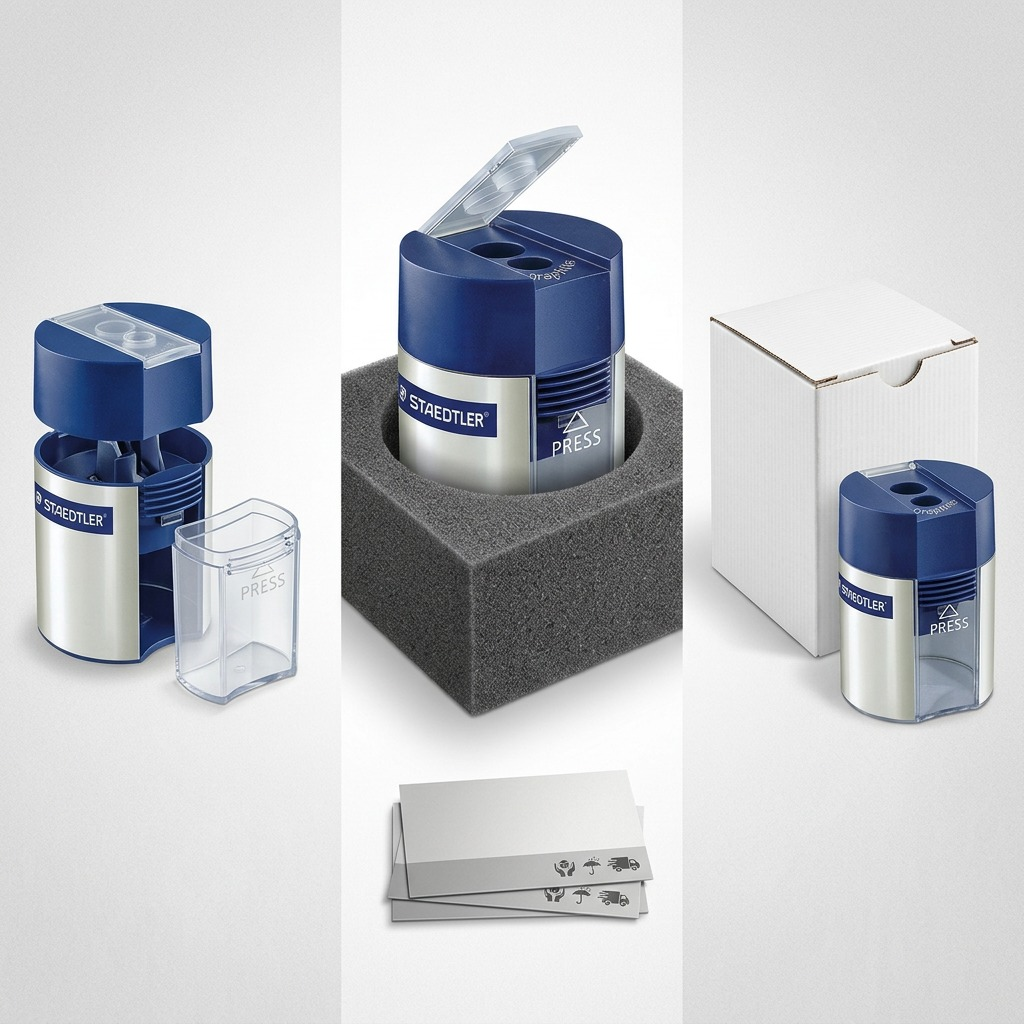 Internal and external views of a STAEDTLER sharpener with open lid and waste container, in protective shipping materials.