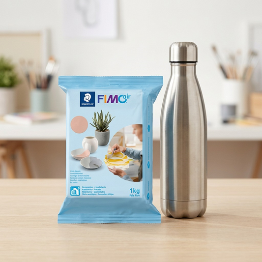 STAEDTLER Fimoair clay package on a wooden table beside a stainless steel water bottle.