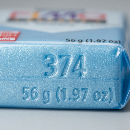 A close-up, macro inspect image of a Fimo Effect block showing a speckled, light-blue texture under fine light and a tiny, indented numeric mark '374'.