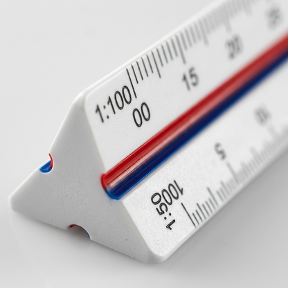 Macro photograph of the STAEDTLER Mars triangular scale ruler, highlighting laser-etched imperial and metric measurements.