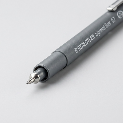 A macro close-up of the metal-clad 0.7mm tip and precision marking on the STAEDTLER pigment liner.