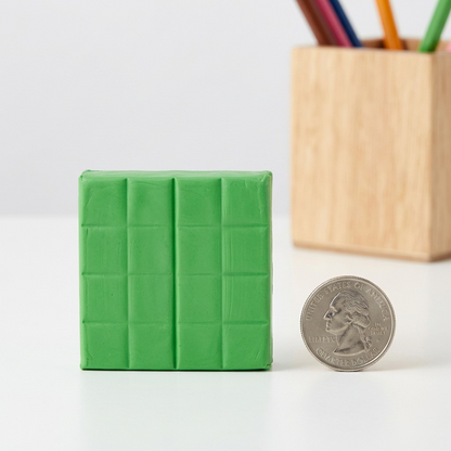 Fimo Soft tropical green clay block with score lines next to a quarter coin for size and scale.