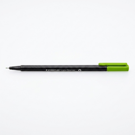 A crisp, central product shot of the STAEDTLER triplus fineliner (green) on white, featuring its unique hexagonal body and metal-clad tip.