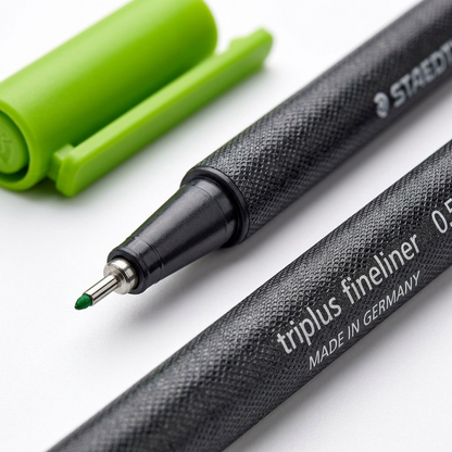 Extreme macro photo showing the detailed mesh texture of the STAEDTLER triplus fineliner barrel and a sharp focus on the fine 0.5mm tip.