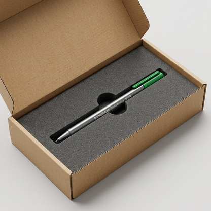 A premium Staedtler Triplus fineliner pen nestled in a custom protective foam insert within a sturdy open shipping box.