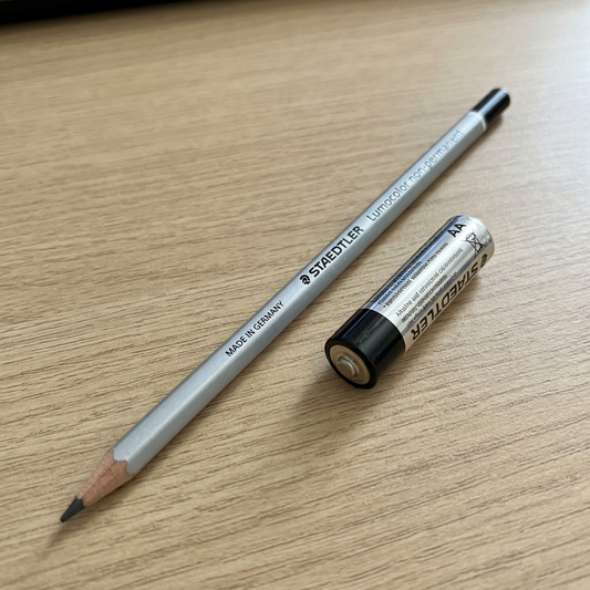 Scale reference photo: The STAEDTLER non-permanent pencil lies next to a standard AA battery.