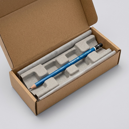 A photograph of the STAEDTLER Mars Lumograph 6B pencil resting secured within protective cushioning inside a cardboard shipping box, representing a robust delivery process.