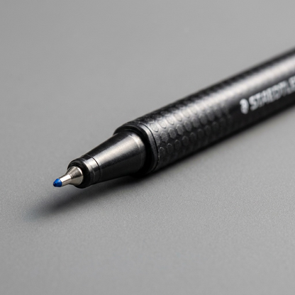A macro photo focuses on the pen's fine point, tip, and blue color.