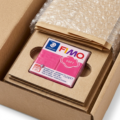 A macro photo shows FIMO Soft Raspberry packaging protected by layers of cardboard, ready for shipping.