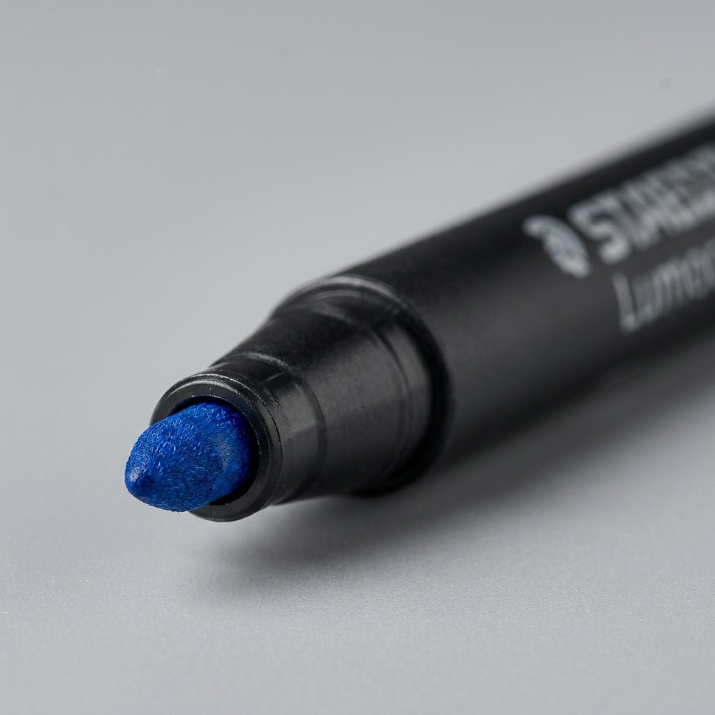 Extreme macro view of the blue STAEDTLER permanent marker tip and nib showing texture.